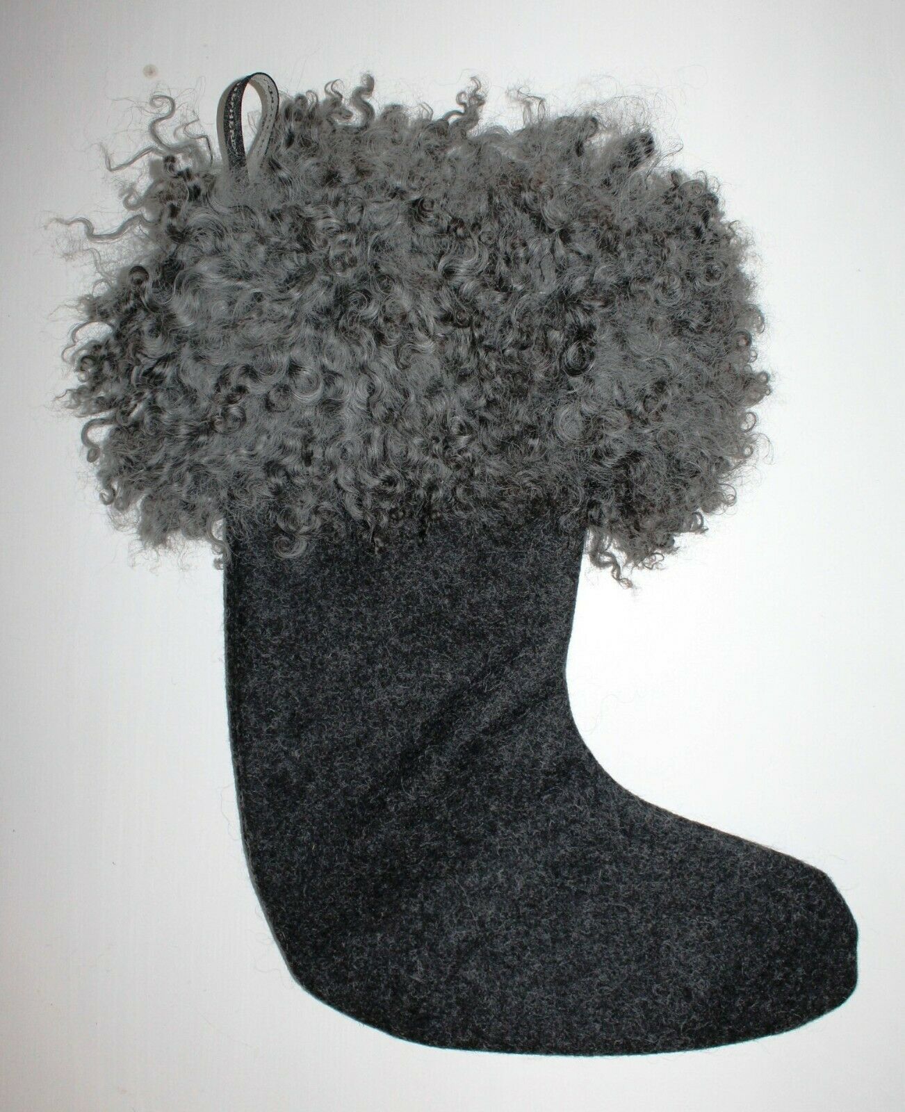 The Shepherd of Sweden Christmas Stocking, Franni in Sheepskin, Black, features a dark felt body with a thick sheepskin trim, shown hanging against a plain white background.
