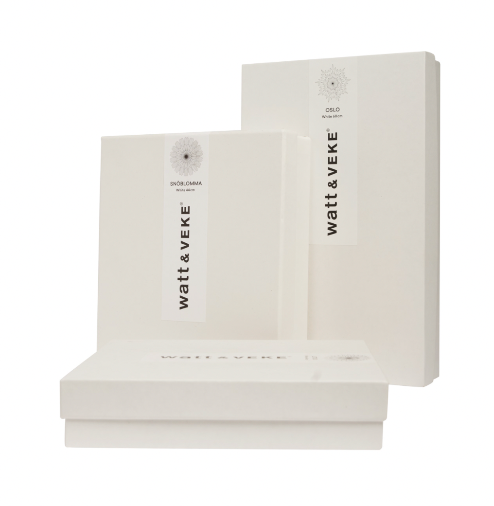 Three white rectangular boxes with minimalist design, branded “Watt & Veke,” are displayed on a white background—ideal for gifting the elegant Star Maja in Paper, Gold 60cm in Box.