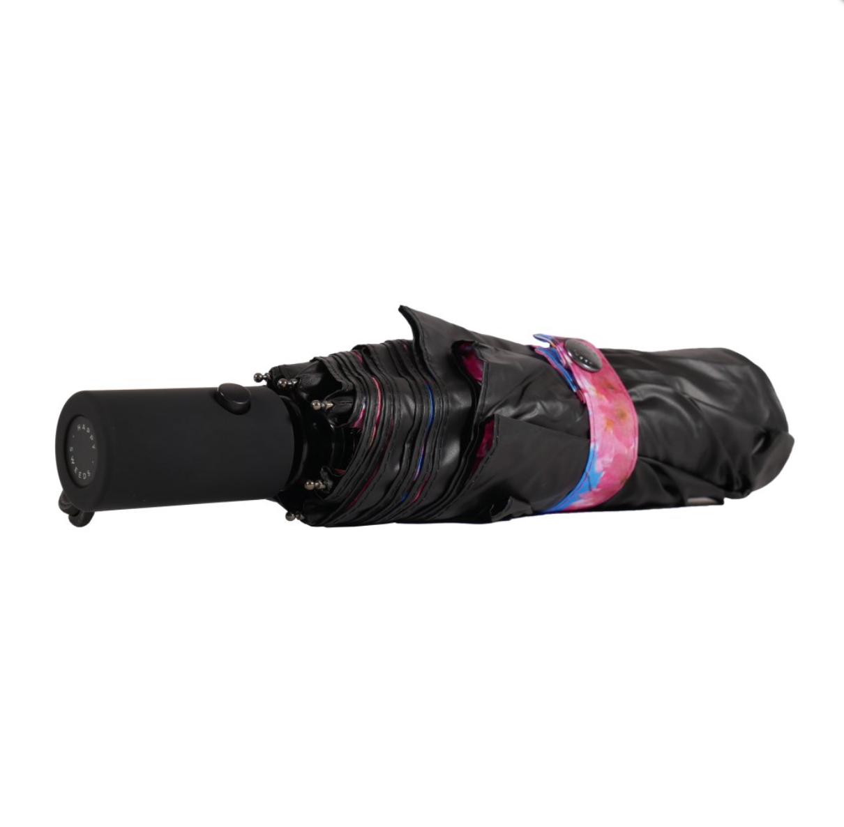 The Happysweeds Umbrella Cherry, a compact and windproof umbrella featuring a pink and blue strap, lies closed on a white background.