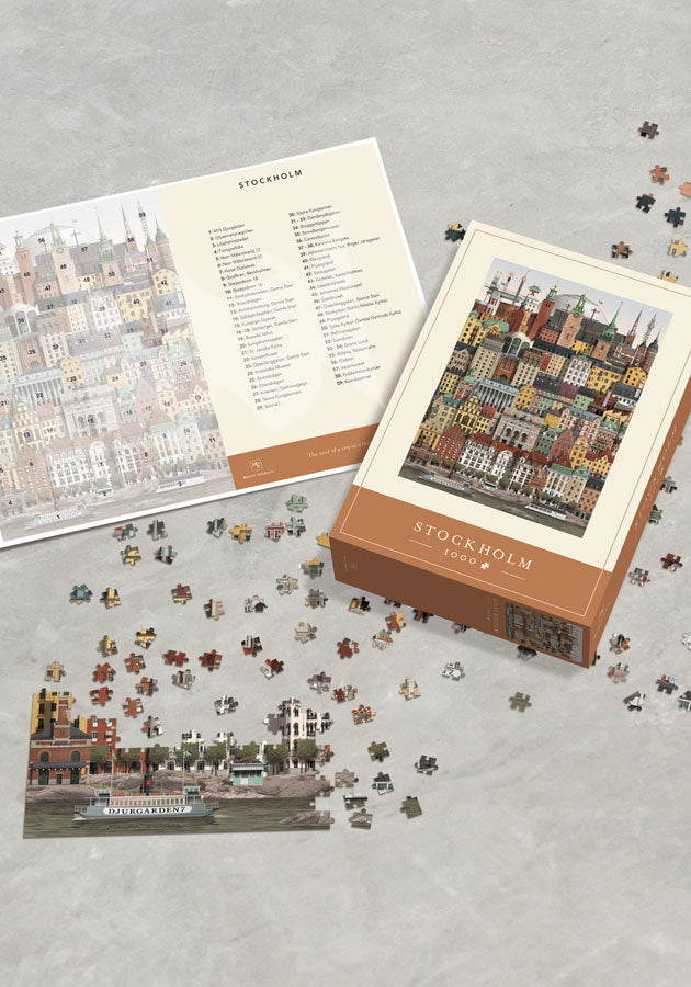 The Martin Schwartz Puzzle Stockholm City, 1000 Pieces, is shown with its box, guide, loose pieces, and a partly completed section featuring iconic city buildings on a light gray surface.