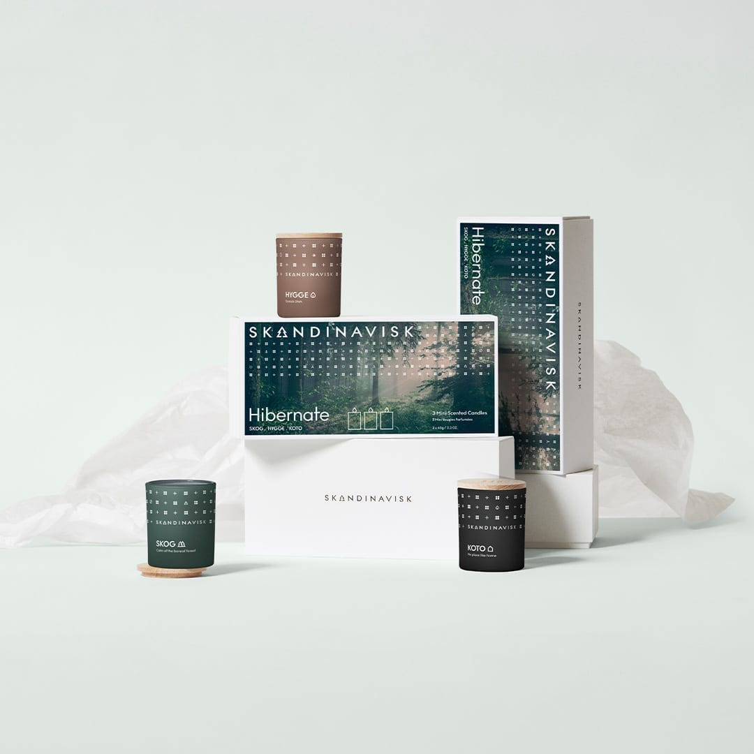 The Skandinavisk Scented Candle Hibernate Mini Giftset features Skog, Koto, and Hygge varieties, all made from Swedish rapeseed wax, beautifully presented as a charming gift set on white boxes.