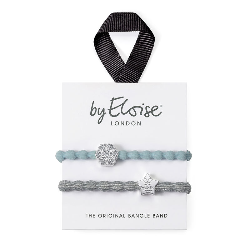 A pack of two ByEloise Bangle Bands on a white card, featuring the Ice Queen set: one with a snowflake charm on blue, and one with a silver star charm on metallic silver.