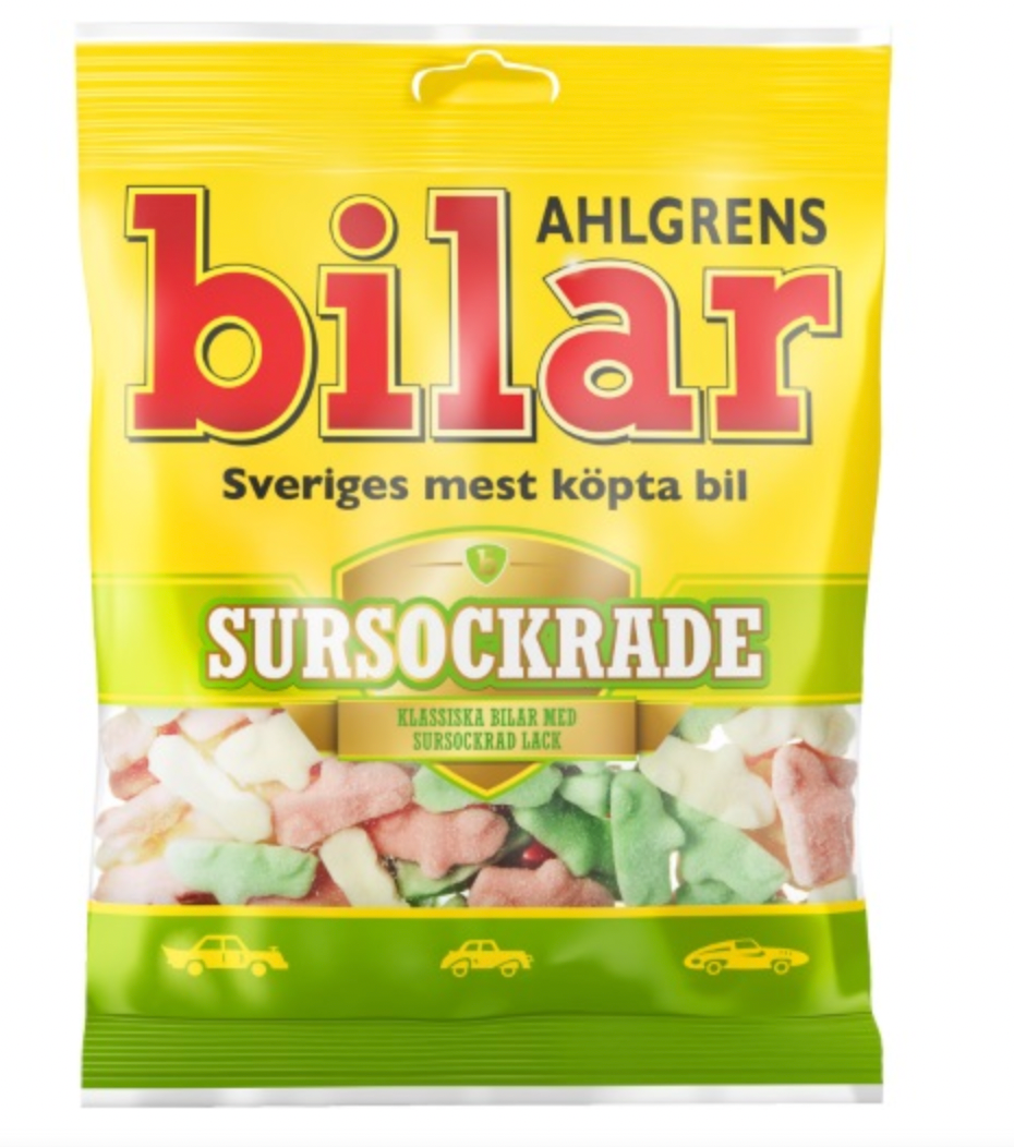 A 100g bag of Deli Ahlgrens Bilar Sursockrade features pastel-colored, car-shaped Swedish sour sweets in a vibrant yellow package.
