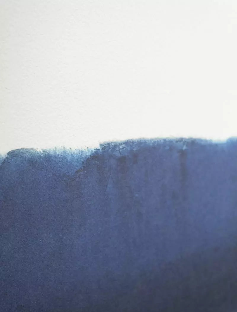 A close-up of a textured blue watercolor paint stroke on white paper, inspired by Fine Little Day’s Ocean 1 Print (40x50 cm), ideal for a limited edition dip dyed poster.