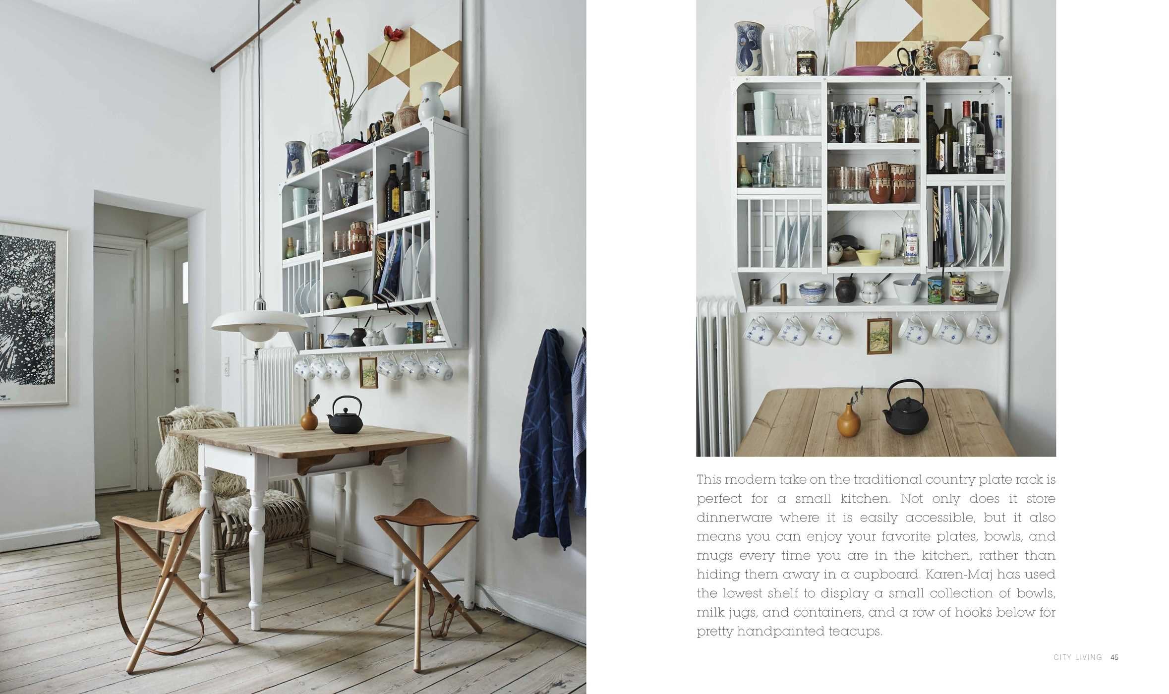 A small kitchen inspired by The Scandinavian Home by Niki Brantmark features a wooden table with two chairs, open shelves displaying dishes and mugs, and kitchen items neatly arranged in true Scandinavian style.