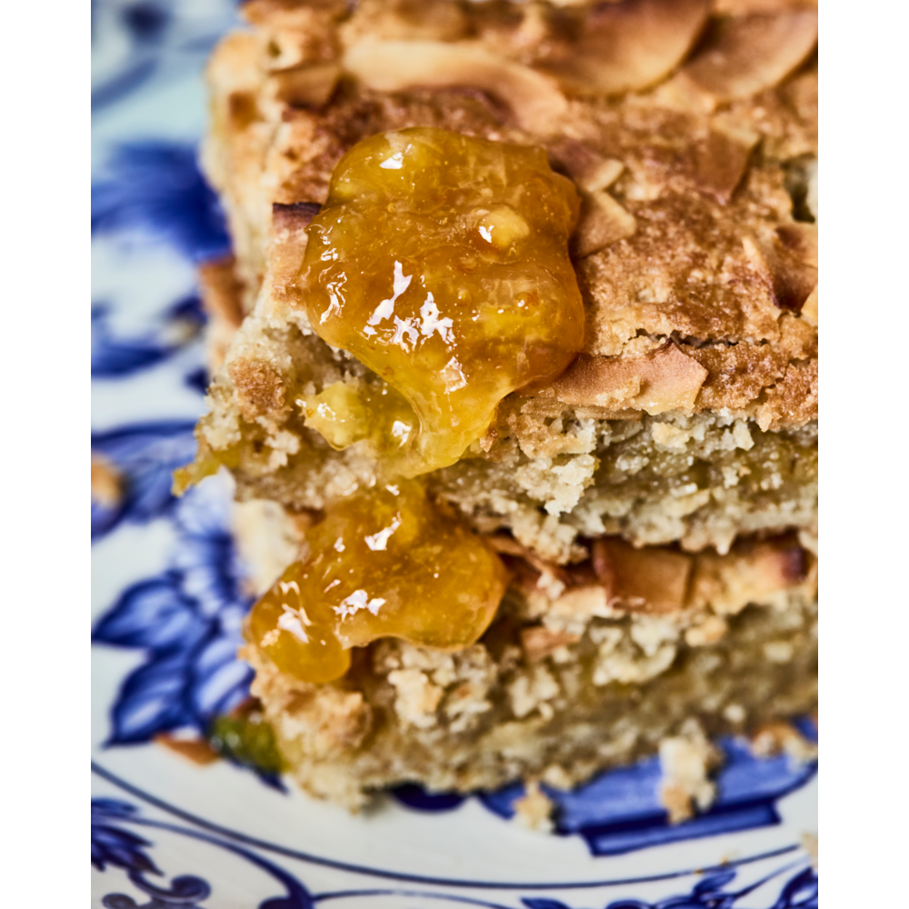 Two stacked slices of baked cake topped with Nicolas Vahé Jam Seasonal, Sweet Orange on a blue and white patterned plate.