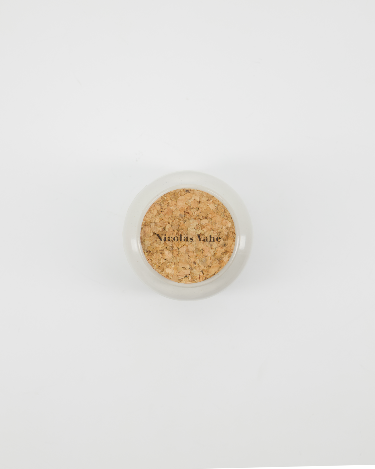 A round white container with a cork lid stamped "Nicolas Vahé," seen from above. Designed for Mustard, Honey & Whole Grain by Nicolas Vahé, it rests against a plain white background.