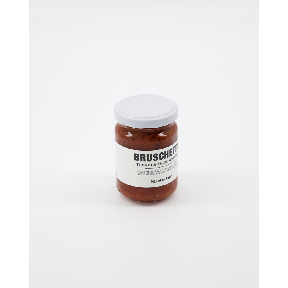 A glass jar with a white lid, labeled "Bruschetta, Tomato & Taggiasca Olives" by Nicolas Vahé, is centered on a plain white background.