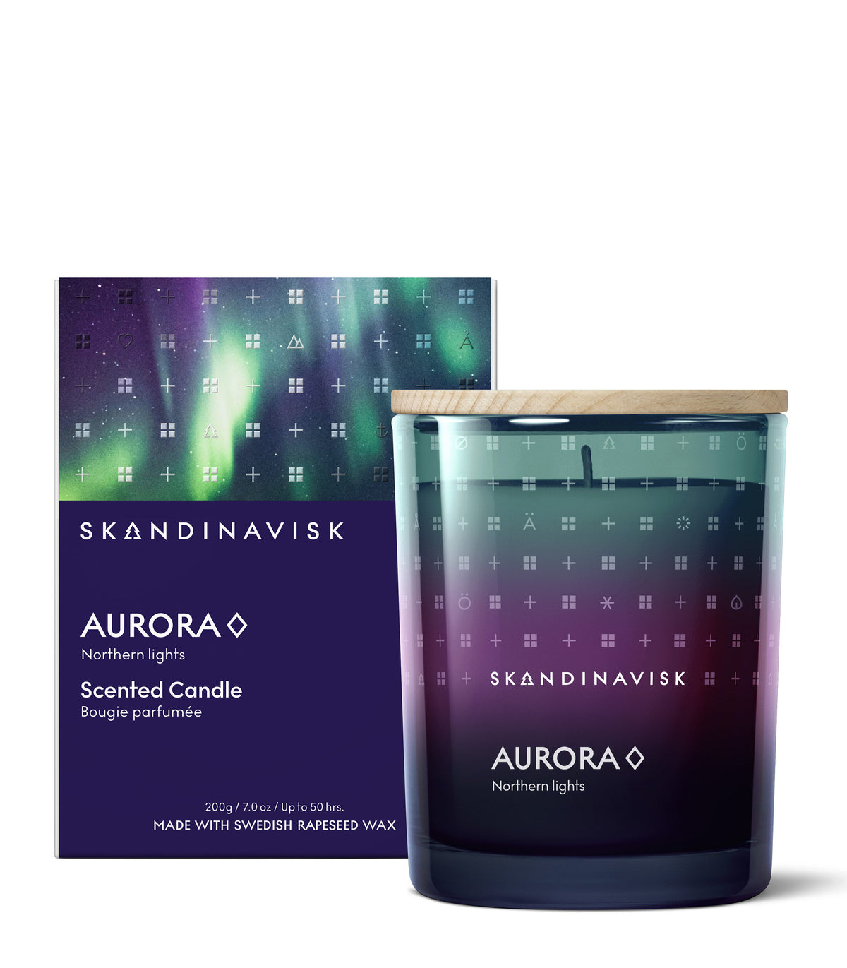 The Skandinavisk Seasonal Scented Candle Aurora (200 g) with a wooden lid is displayed beside its box, both showcasing a northern lights-inspired design and the brand’s logo. Made from Swedish rapeseed wax, the candle glass echoes the same gradient pattern with white lettering, inviting you to experience notes of sandalwood and juniper berries.