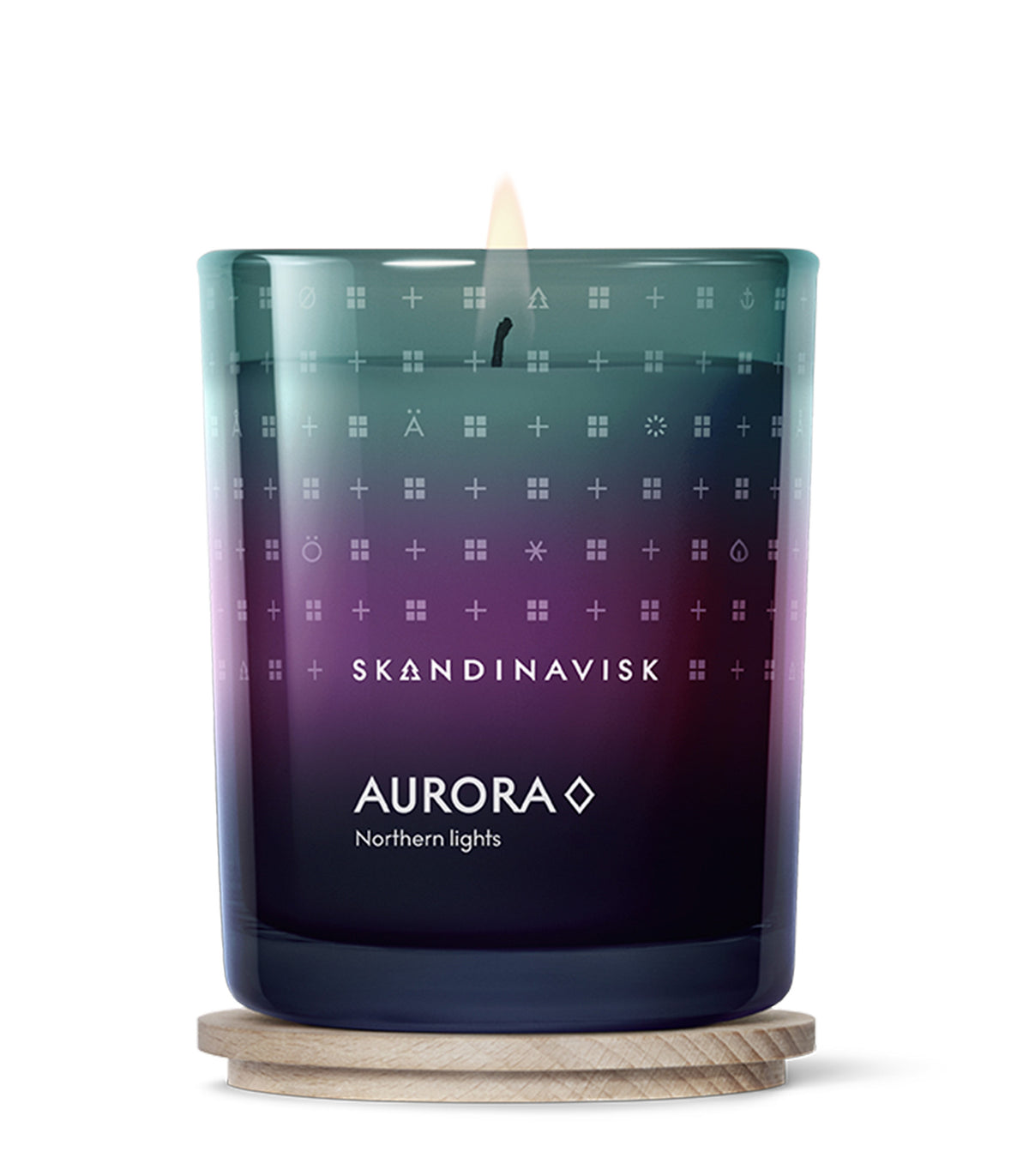 A glowing Skandinavisk Seasonal Scented Candle Aurora, 200 g, crafted from Swedish rapeseed wax and scented with sandalwood and juniper berries, stands in a gradient glass holder adorned with minimalist symbols and white text atop a wooden coaster.