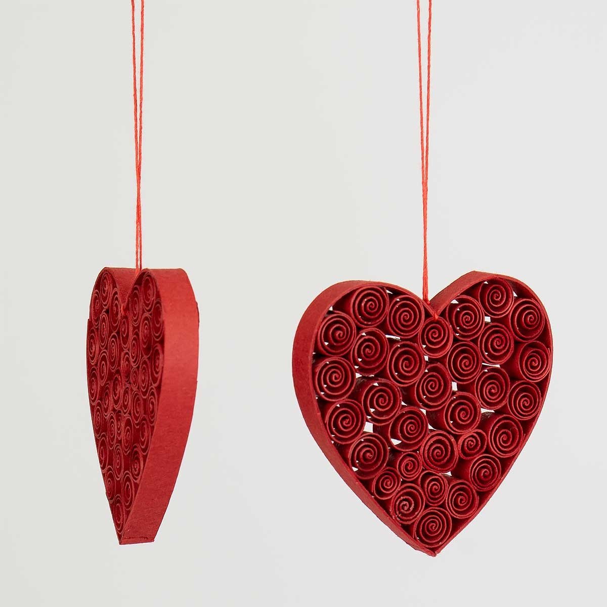 A World of Craft Quilled 2 pack Heart Christmas Ornament in Red features two handmade heart ornaments hanging from red strings against a plain white background.
