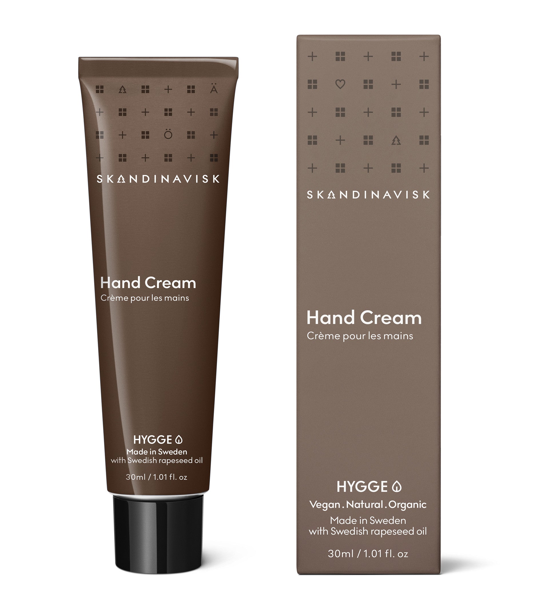 A brown tube and matching box of Skandinavisk Mini Hand Cream Hygge (30 ml), a vegan moisturiser from Scandinavian skincare, made in Sweden with Swedish rapeseed oil, organic aloe vera, and other natural ingredients.