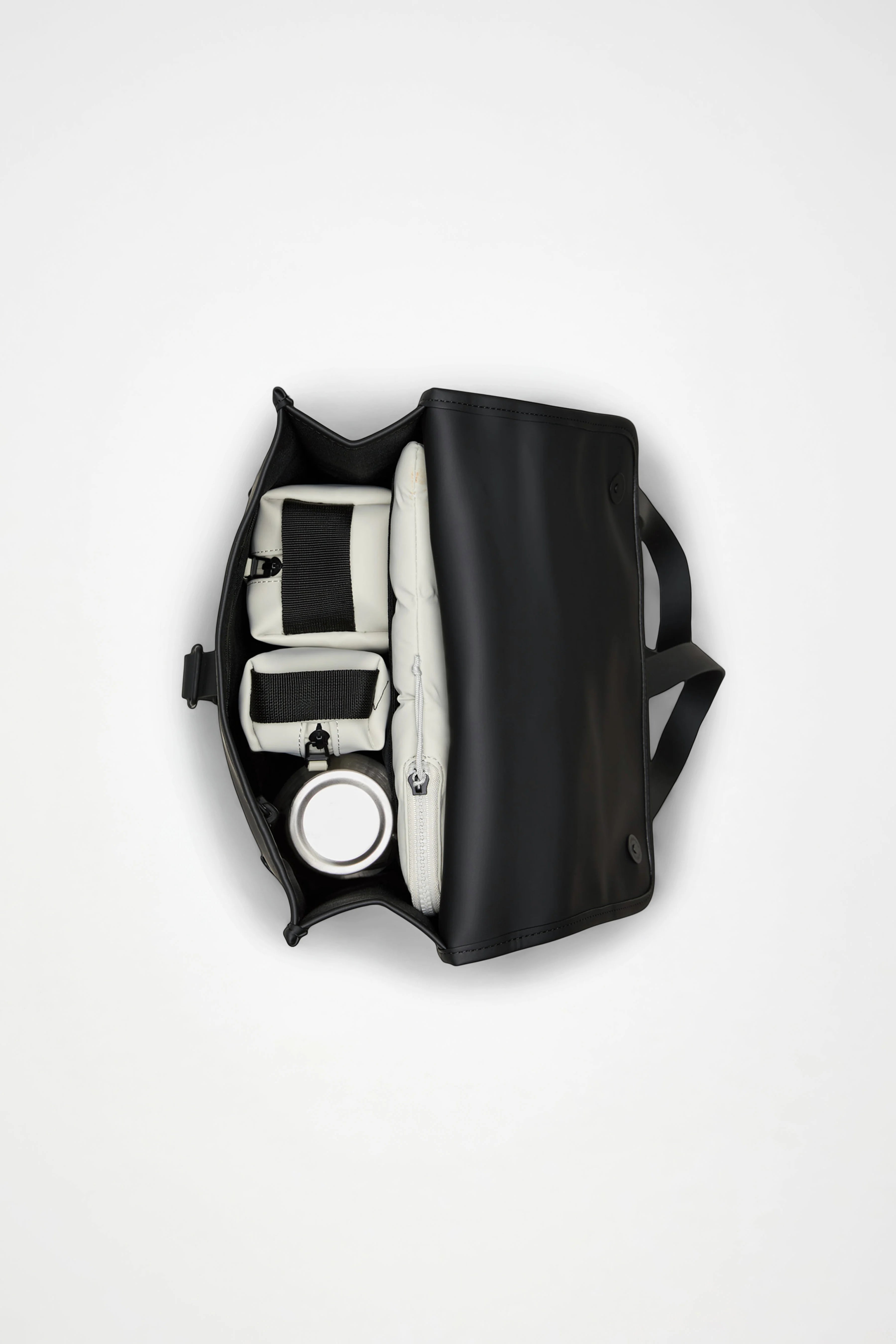 A beige Rains Backpack Mini Bag by Rains, viewed from above on a white background, partially open to display neatly organized white compartments containing various items—including a water bottle and a zippered pouch.