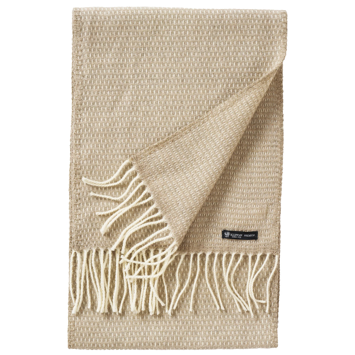 A taupe Hugo Scarf from Klippan Yllefabrik, crafted from recycled and new merino wool for an eco-friendly touch, features a woven texture with white fringe on the ends and a small black label in one corner—evoking the elegance of a premium throw blanket.