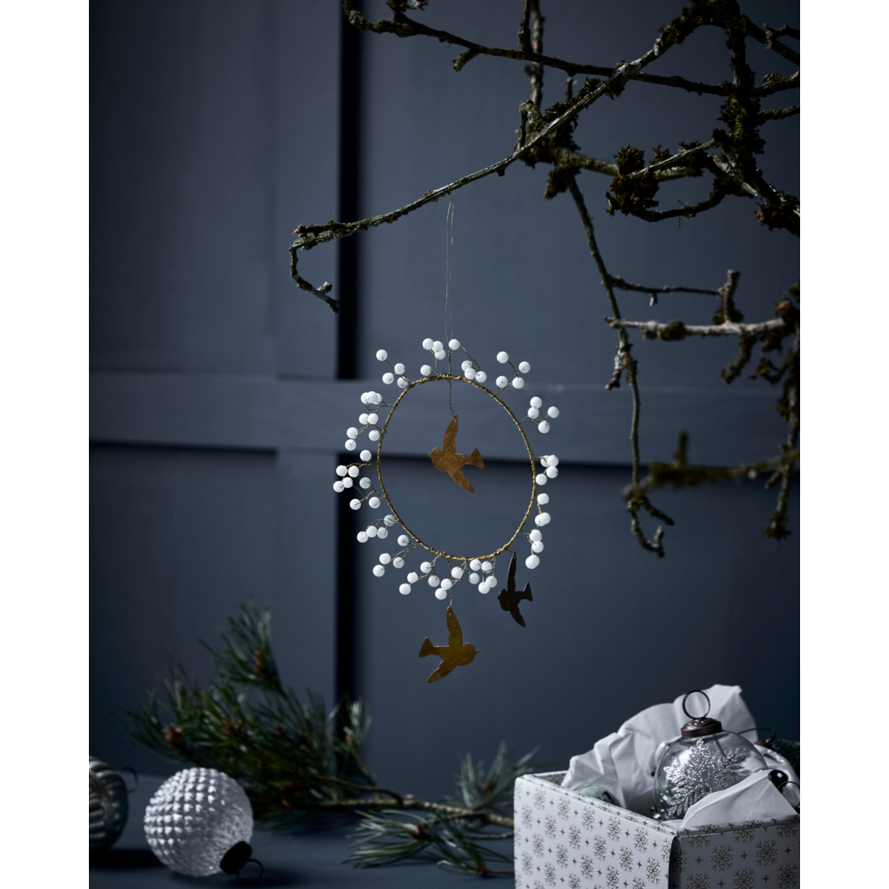 A circular, handcrafted House Doctor Christmas Ornament, Bird in White & Brass featuring small birds and white beads hanging from a tree branch.
