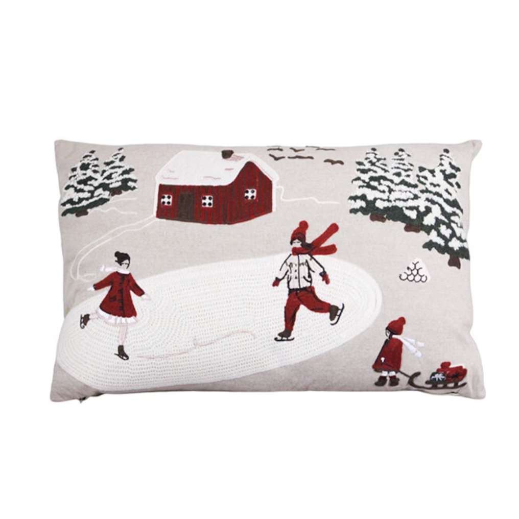 The Strömshaga Cushion Cover Vinterland Embroidered (40 x 60 cm) features children ice skating and sledding by a red house and snowy trees, adding cozy seasonal charm to your decor.