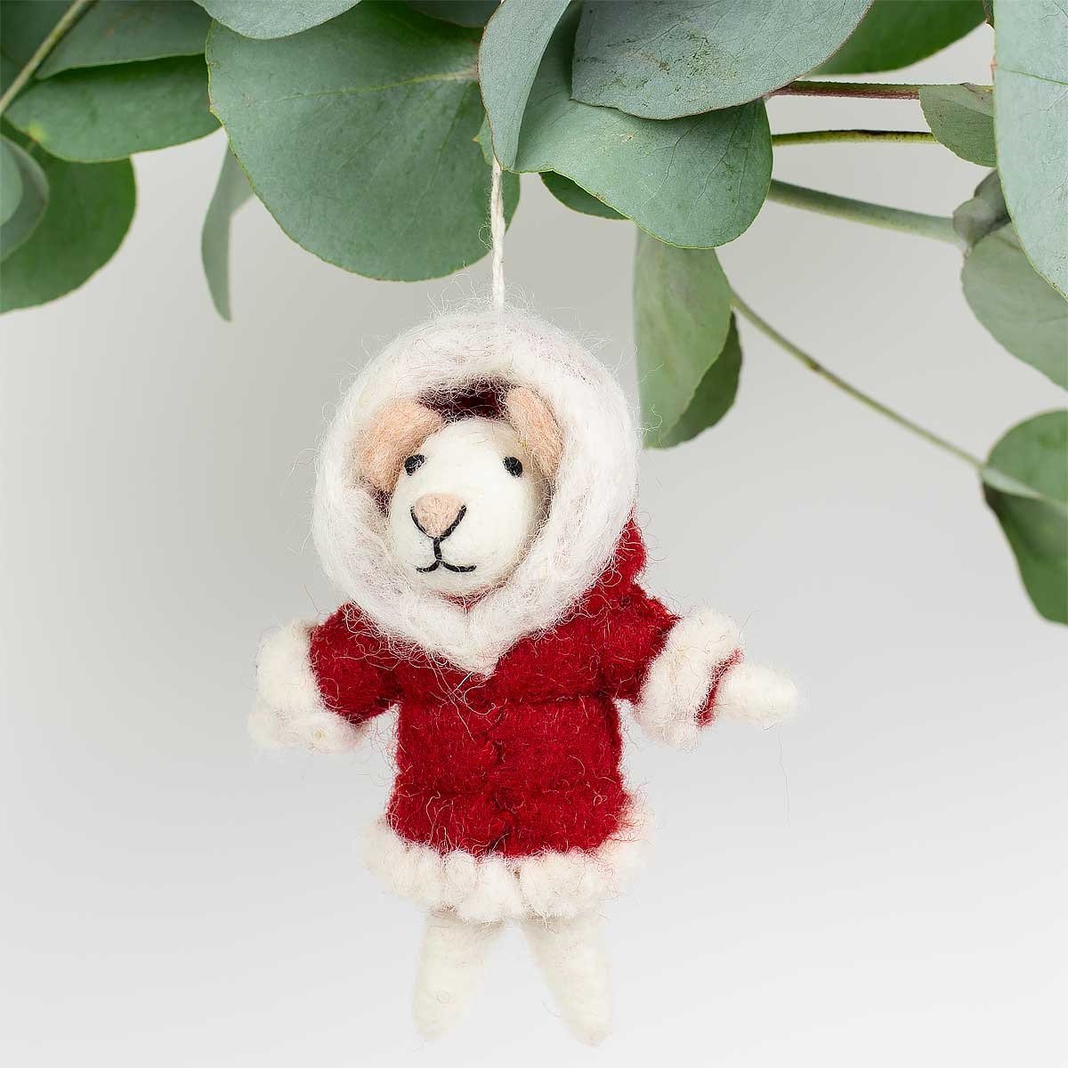 The Santa Mouse Lady Christmas Ornament by A World of Craft is a handmade 11cm wool mouse wearing a red and white parka, hanging from a string with green leaves in the background.