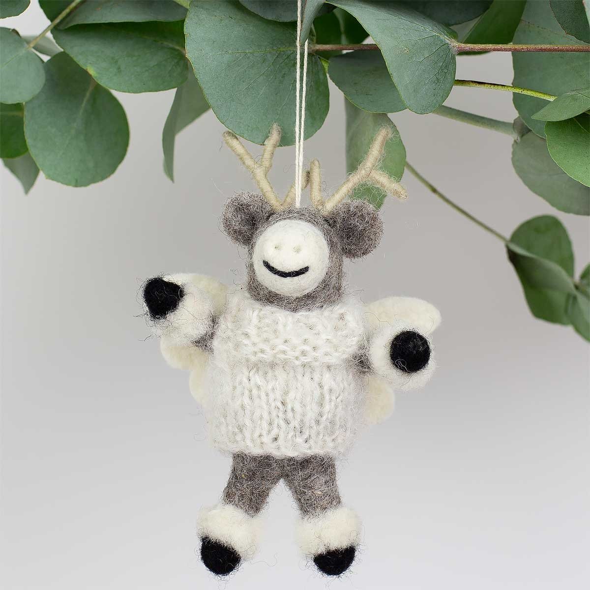 The Elk Angel Christmas Ornament by A World of Craft is a 14cm handmade wool ornament featuring a felt reindeer with a white sweater and antlers, hanging from a string.