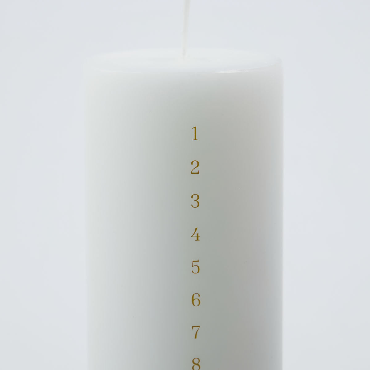 The House Doctor Calendar Candle 24 days of Christmas, Forest in White (6cm), features gold numbers 1 to 24 vertically printed on its white cylindrical form—ideal for counting down to Christmas against a plain light background.
