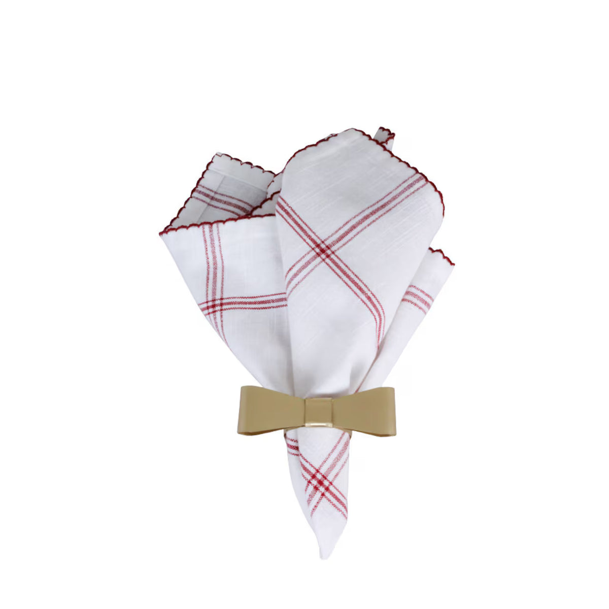 A white cloth napkin with red plaid lines is elegantly folded and secured by the Strömshaga Napkin Ring Bow Brass—a decorative brass bow—creating a refined table setting against a plain white background.