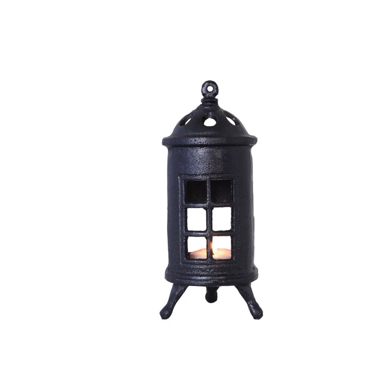 The Strömshaga Stove Candleholder for Tea Lights, crafted in black cast iron with window details and three legs, holds a glowing tealight—ideal for adding rustic vintage charm to your décor.