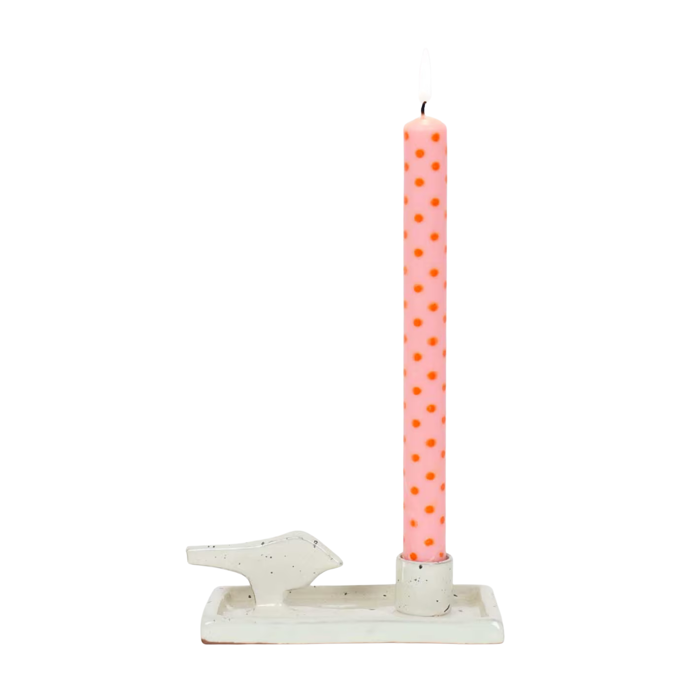 A pink taper candle with orange polka dots sits in the Candle Holder Earth Bird by A World of Craft, a handmade white stoneware candlestick shaped like a rectangle with a small bird figure on one side.