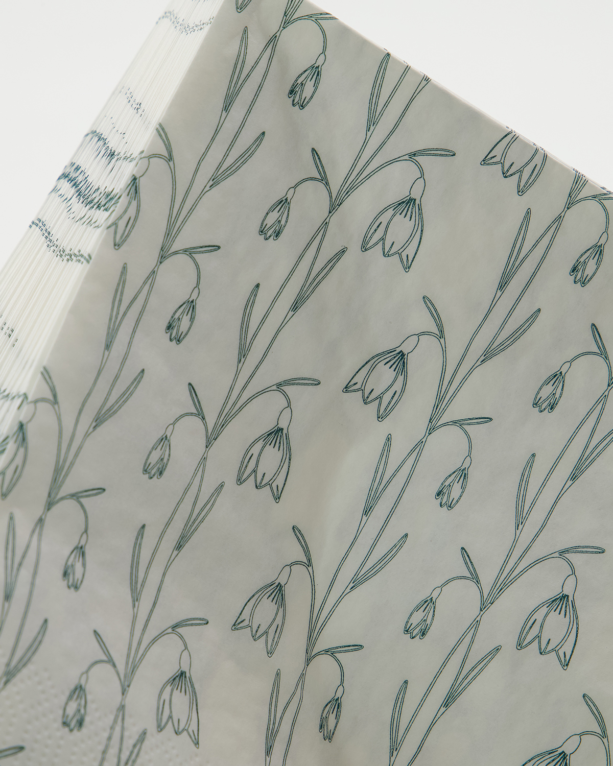 The House Doctor Snowdrop Napkins in White & Green, Pack of 40, feature a delicate green line-drawn floral pattern with bell-shaped flowers—ideal for adding a seasonal touch to your table settings.