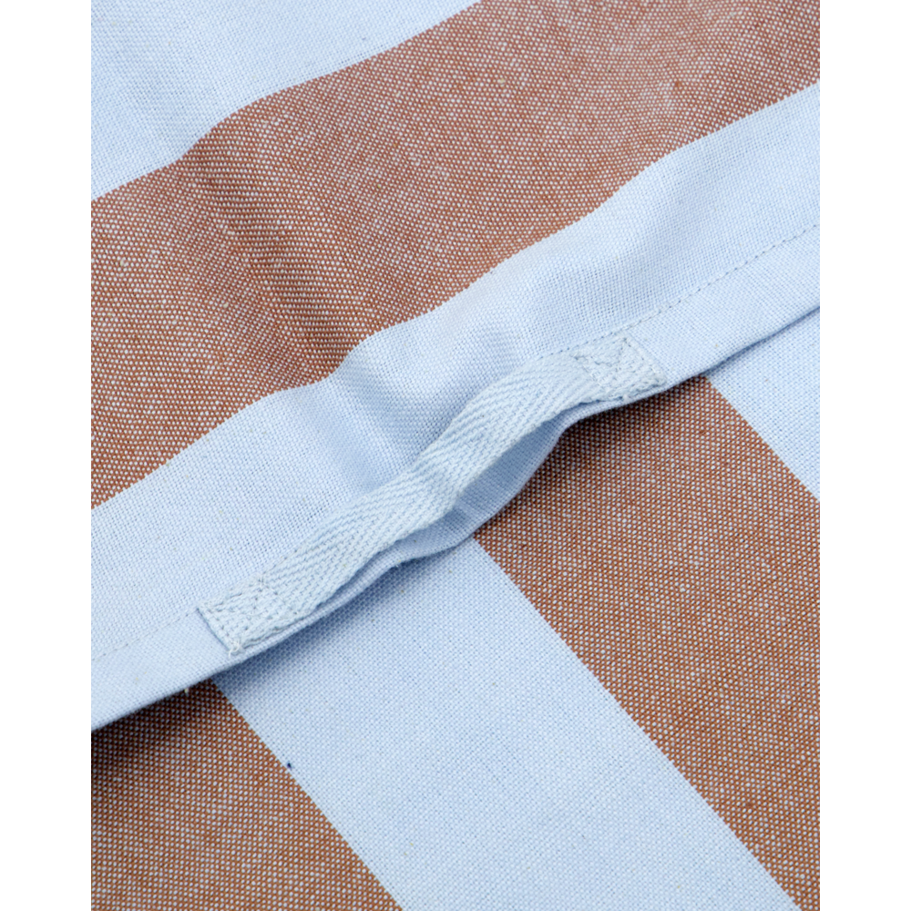 Close-up of House Doctor Tea Towels Cook, Light Blue & Brown, Set of 3. Wide stripes and a sewn seam create a gentle fold, highlighting the absorbent cotton's texture and stitching details.