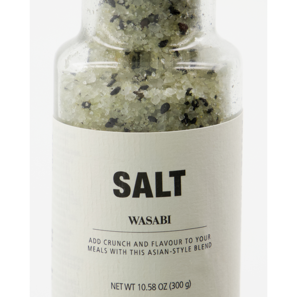 A close-up of a bottle labeled "Salt, Wasabi" by Nicolas Vahé, containing coarse wasabi salt with green and black specks, including black sesame seeds. The Asian-style seasoning blend has a net weight of 10.58 oz (300 g).