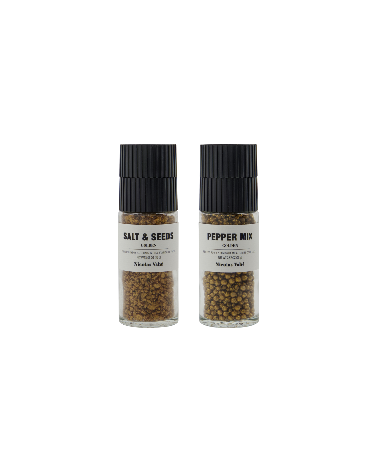 The Nicolas Vahé Gift Box includes two glass grinders: Golden Salt & Seeds and Golden Pepper Mix, each with a black lid and a visible blend of spices and seeds.