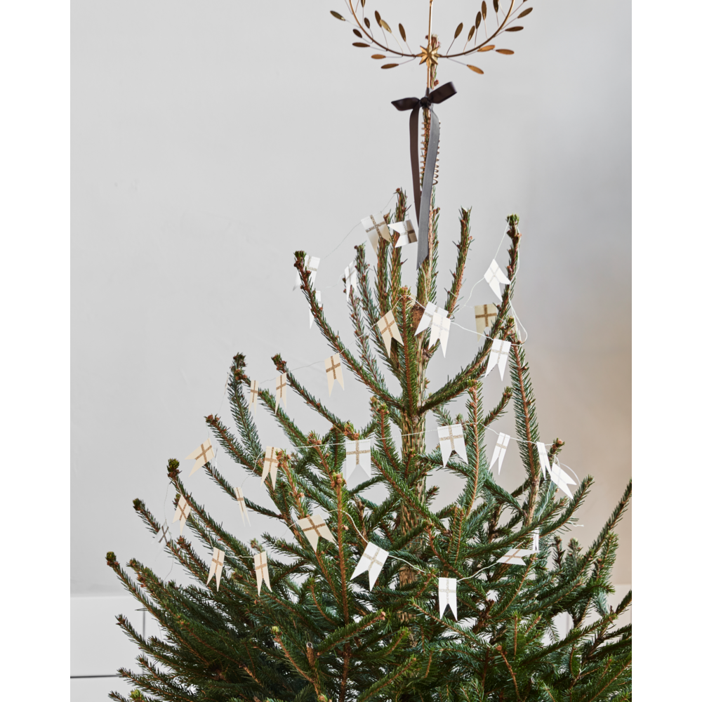 A Garland Flags in White & Champagne of small white and champagne-colored paper flag ornaments draped across a Christmas tree.