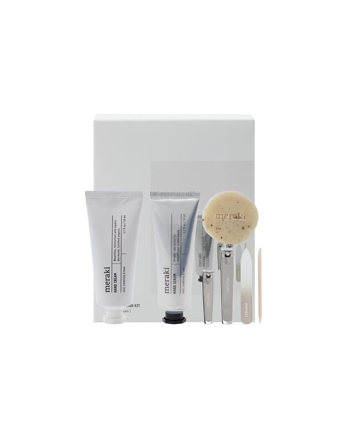 A minimalist nail kit by Meraki, featuring hand care essentials—including hand cream, hand serum, soap, and a nail kit—displayed in front of a white gift box on a white background.
