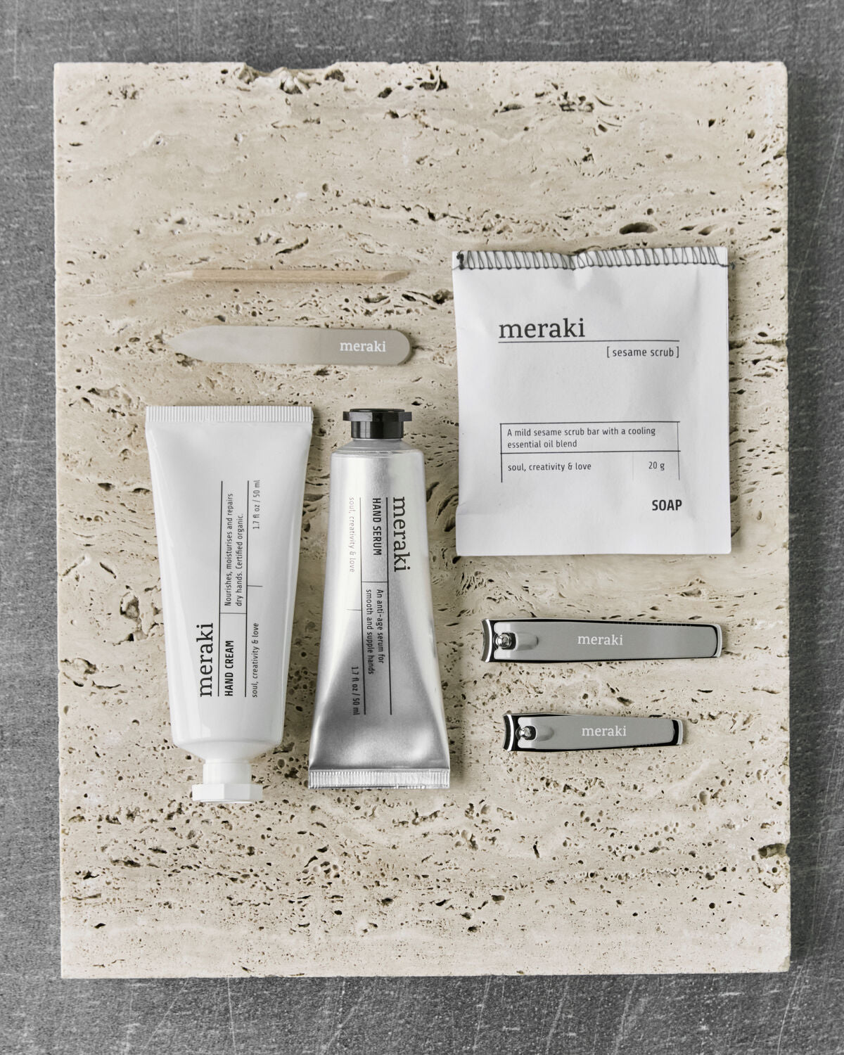 A flat lay of Meraki’s Gift box showcasing hand care essentials, including Hand Cream, Hand Serum, Soap, and a Nail Kit—this thoughtfully arranged set makes the perfect addition to any nail routine. All items are neatly displayed on a light stone surface.