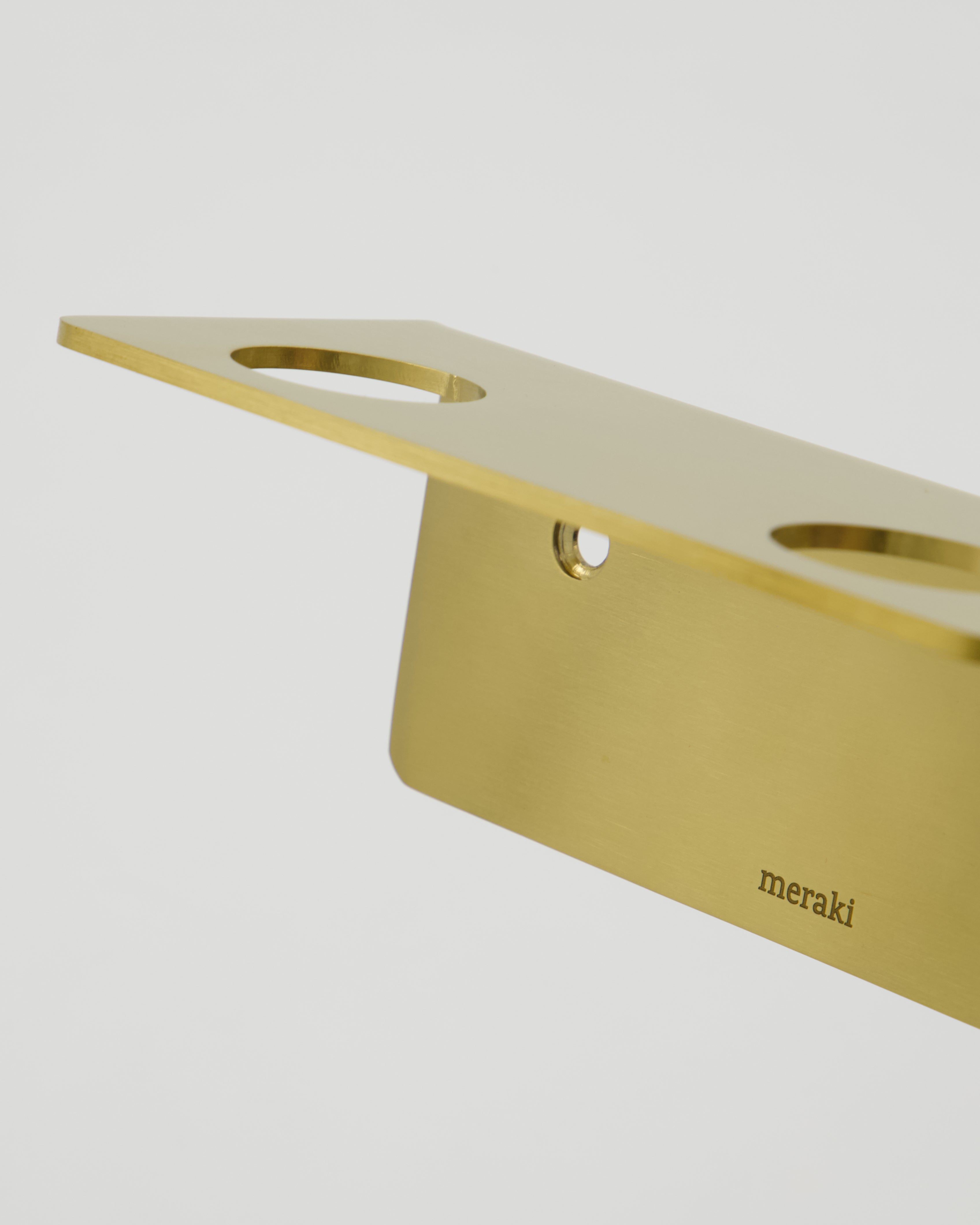 A close-up of the Meraki Bottle Hanger 2 Holes in a brushed brass finish, featuring two holes and the brand name engraved on it, designed as a sleek stainless steel bottle hanger and set against a plain white background.