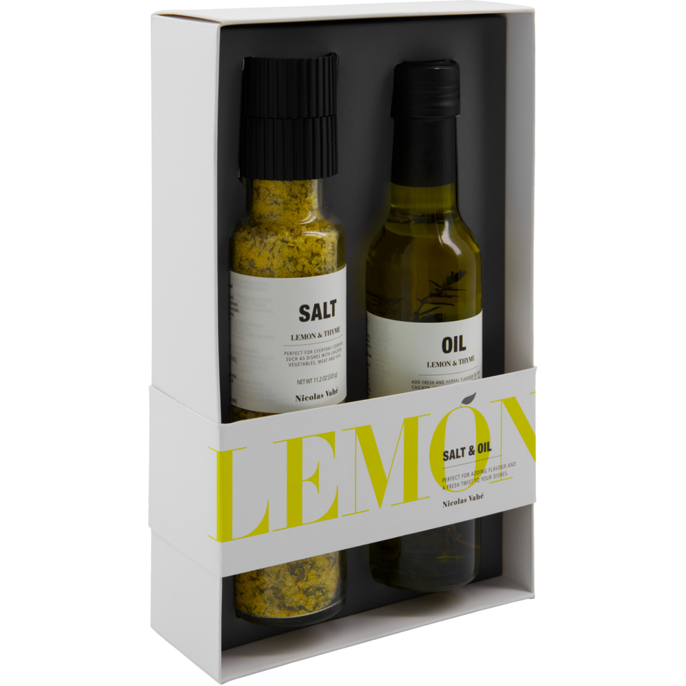Introducing the Salt & Oil Lemon Gift Box from Nicolas Vahé. This elegant gift set features a transparent salt grinder labeled “Salt” and a matching bottle labeled “Oil,” both infused with the fresh flavors of lemon and thyme. The stylish white packaging showcases LEMON in bold yellow letters across the front. Perfect for everyday use, this set brings together lemon and thyme seasoned salt and lemon and thyme oil—ideal for brightening any dish.