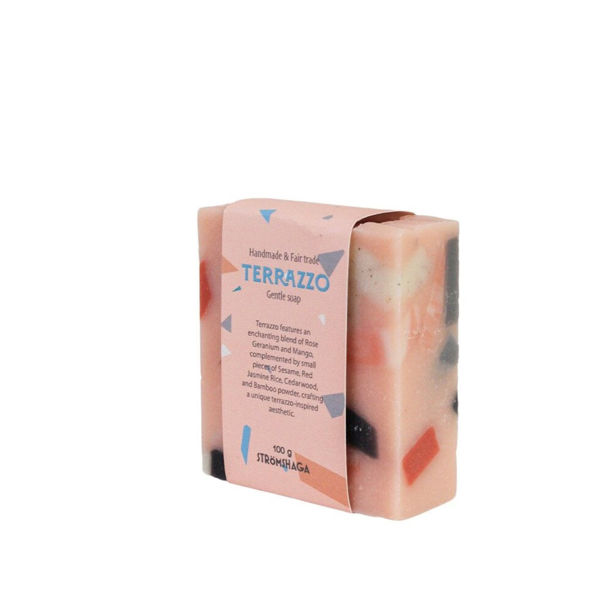 A rectangular bar of Strömshaga’s Terrazzo Handmade & Fairtrade Soap Bar features colorful chunks inside and comes wrapped in pink packaging labeled “Terrazzo Gentle Soap.” Scented with rose, cedarwood, orange, and subtle notes of rose geranium mango for a unique fragrance, this 100g exfoliating vegan soap is artisan-crafted.