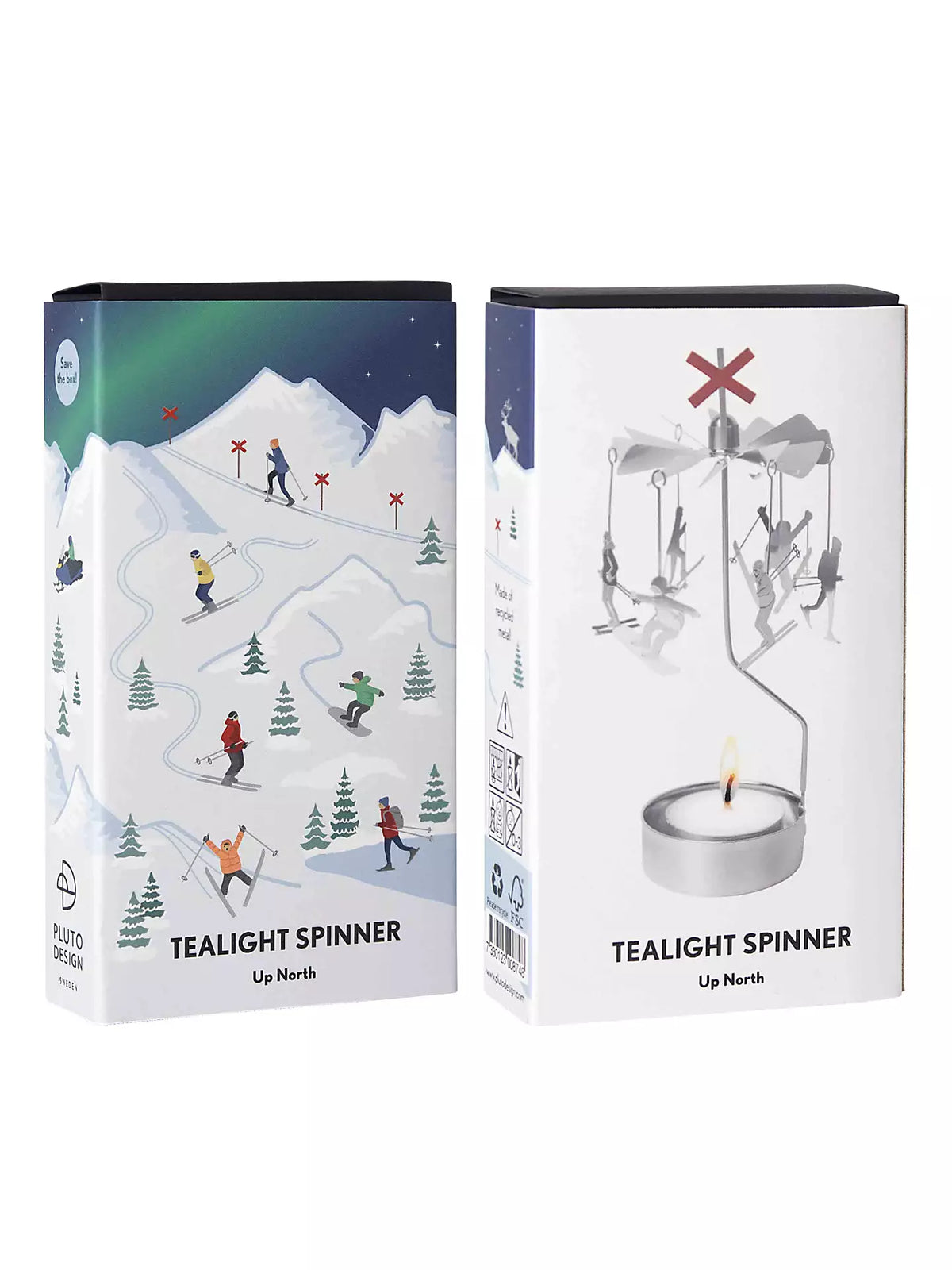 Two boxes of Pluto Design Sweden’s Tealight Spinner, Up North in Silver, are displayed. One box features an illustration of people skiing on snowy mountains, creating a serene mood; the other showcases the tealight spinner itself in use above a flame, emphasizing its distinctive decorative touch.