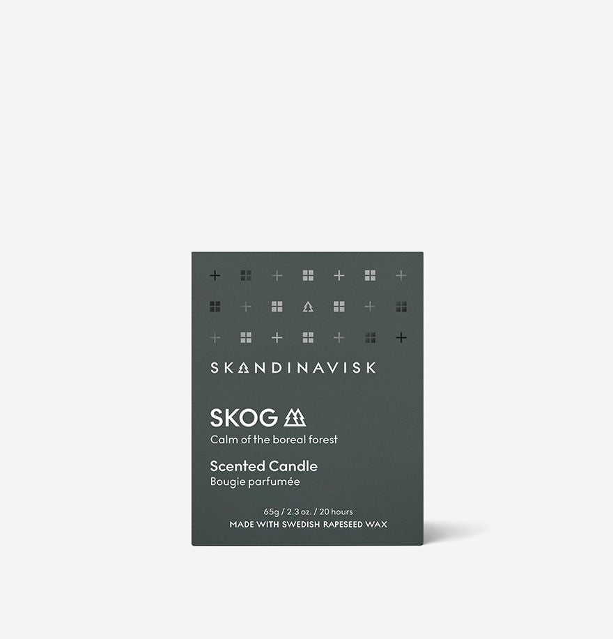 A dark green Skandinavisk Mini Scented Candle Skog 20h, 65g box with white text and product details sits against a plain light background.