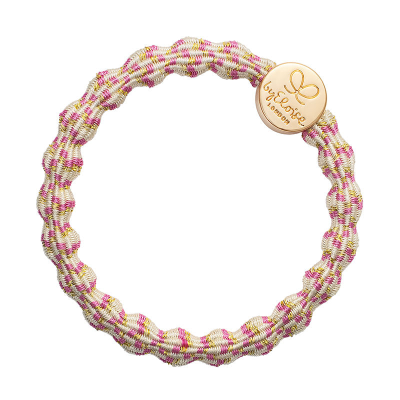 The ByEloise Bangle Band Metallic Gold Circle in Blossom is a stretchy, round elastic hair accessory with a woven cream, pink, and yellow design and a gold charm engraved with a butterfly and “byEloise London.”.