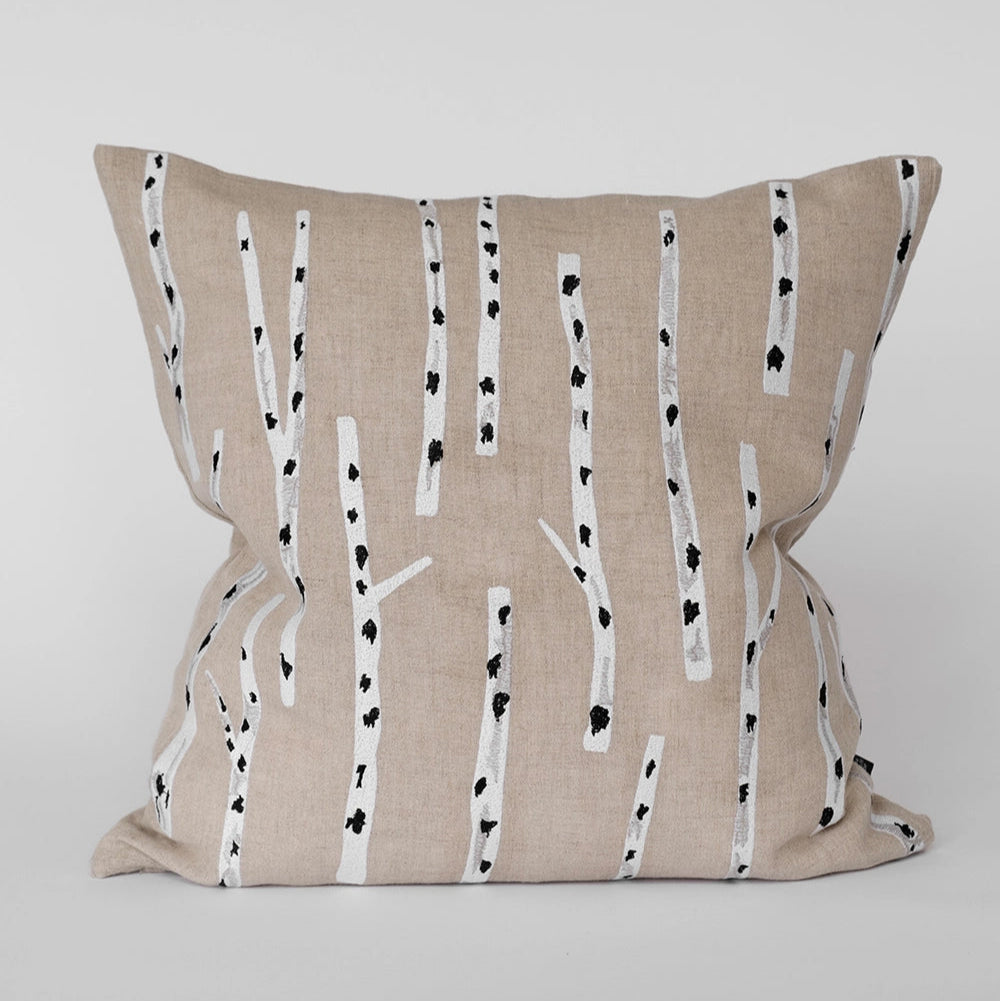The Birch Embroidered Cushion Cover in Nature by Fine Little Day features Elisabeth Dunker's design with white birch tree trunks and black knots on beige linen, set against a plain white background.