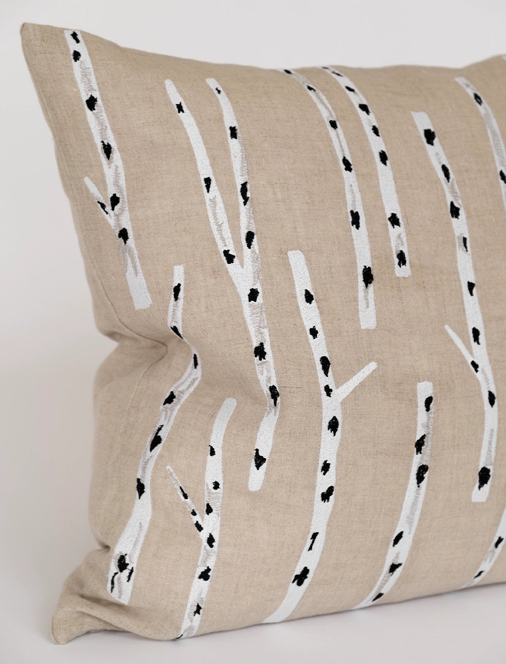 The Birch Embroidered Cushion Cover in Nature by Fine Little Day features white and black birch tree trunks on beige linen, designed by Elisabeth Dunker.