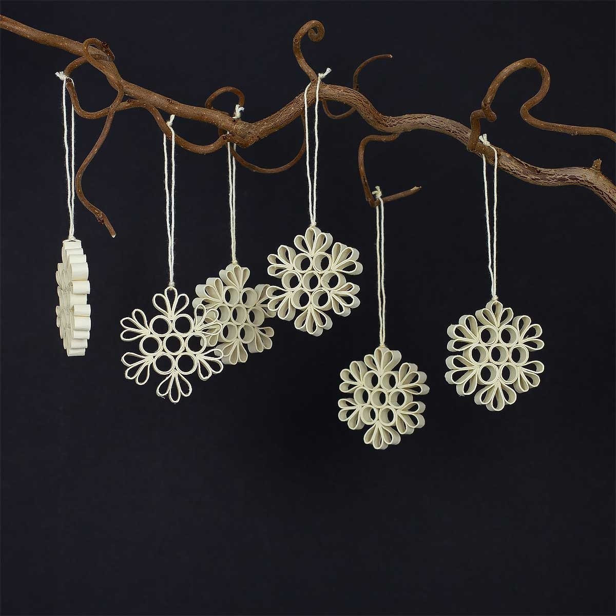 Six beige Quilled Snow Flake Christmas Ornaments from A World of Craft hang against a black background, highlighting their unique, handmade, eco-friendly design.