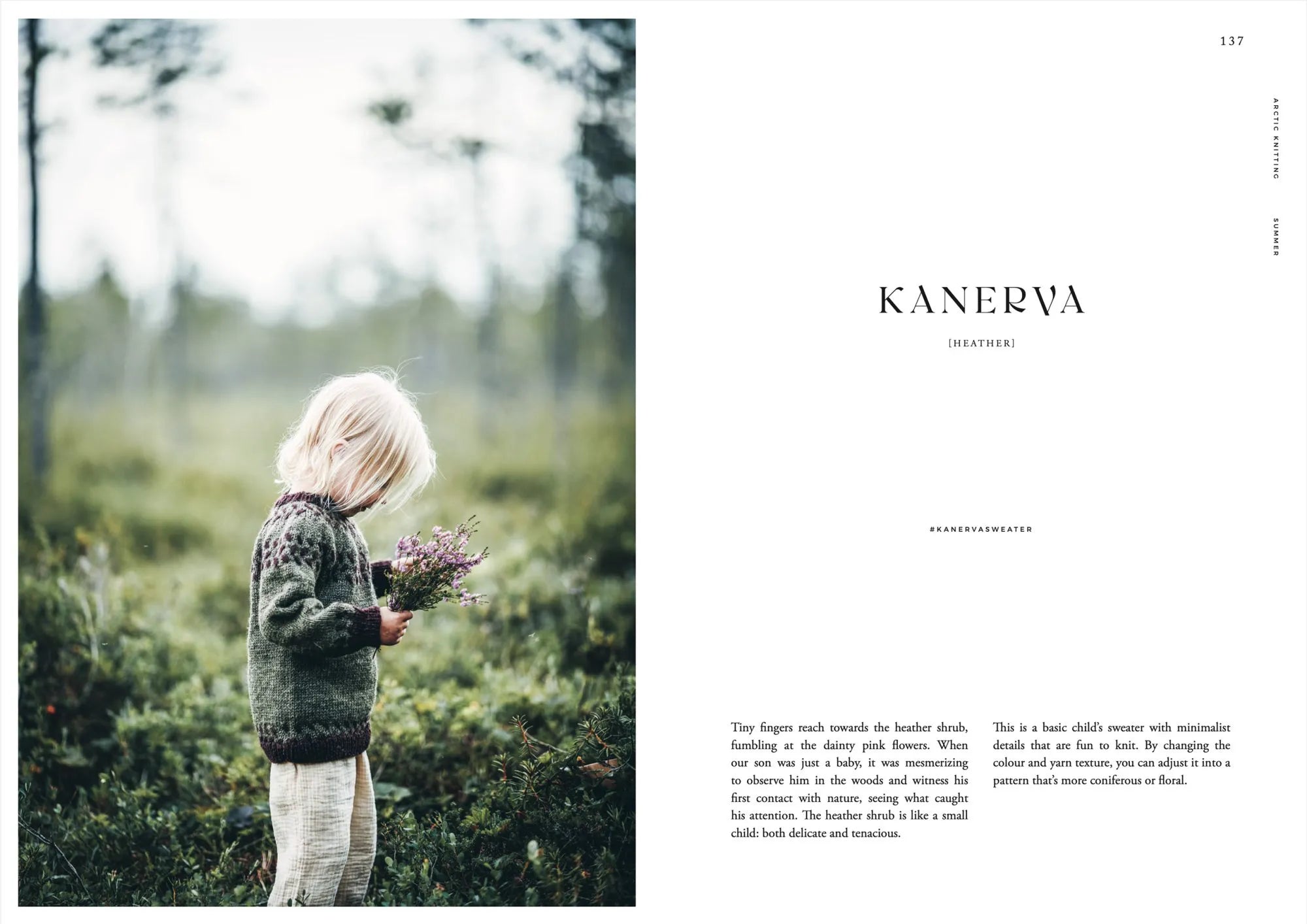 A young blond child in a green sweater with Lapland-inspired patterns stands in a lush forest, holding purple flowers. Sweater pattern from "Arctic Knitting: The Magic of Nature and Colourwork" by Cozy Publishing. Background is softly blurred.