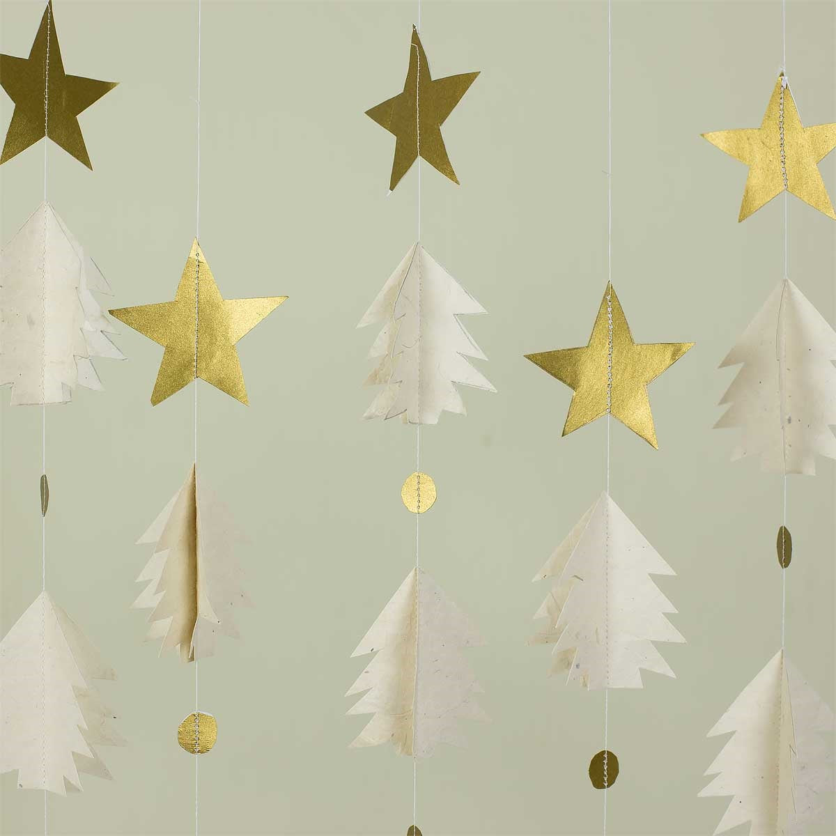 Add a touch of minimalist festivity to your space with the Christmas Night Mobile in Gold & White from A World of Craft—a handmade decoration featuring hanging garlands with gold stars, white paper trees, and gold circles, beautifully arranged vertically against a light background. Perfect as a festive decor accent or as a handcrafted Christmas mobile.