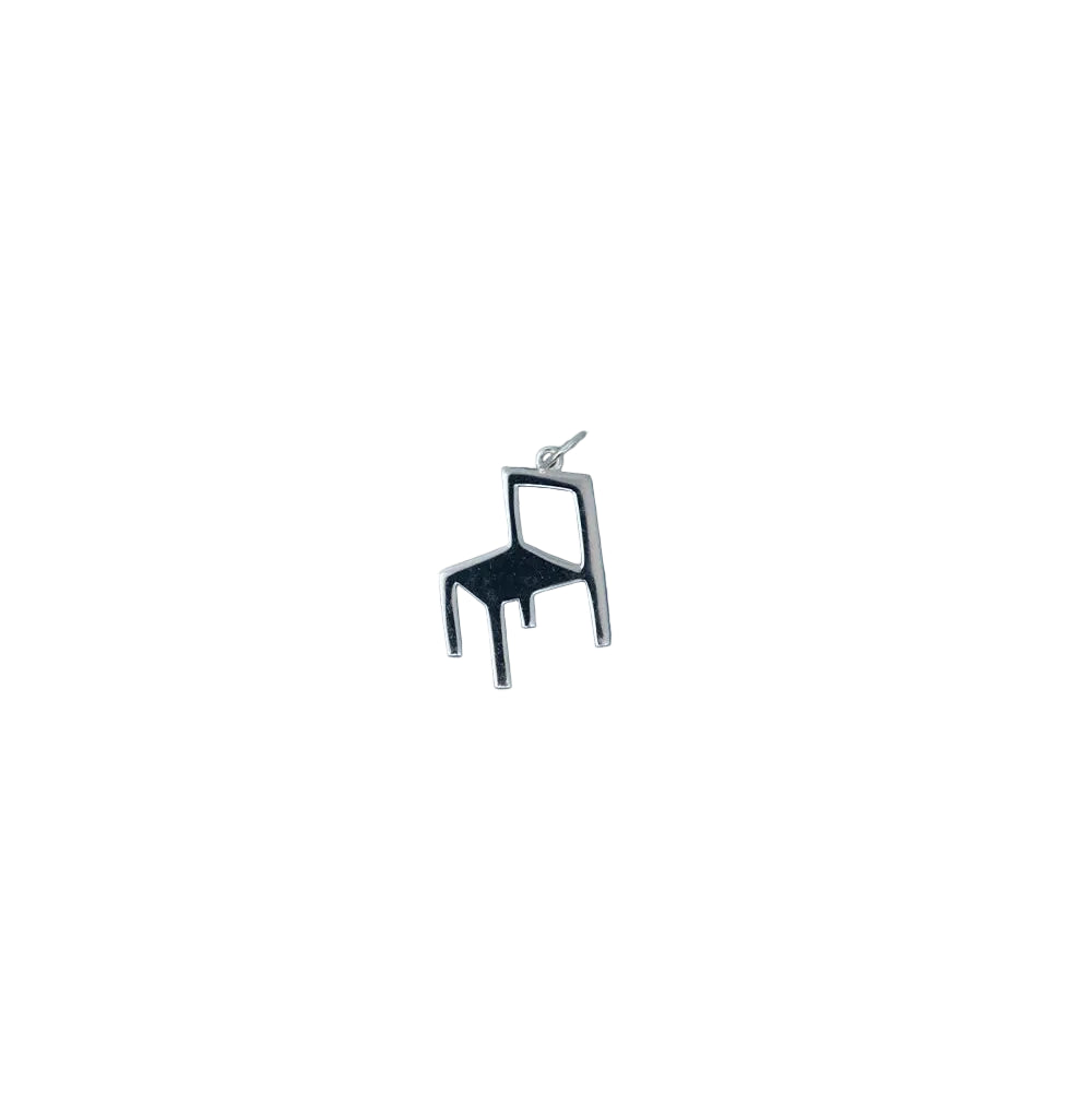 A small, silver pendant shaped like a minimalist chair with a simple geometric design, set against a plain white background. This elegant piece is the Chair Charm in Silver by Fine Little Day—a sterling silver necklace crafted from recycled silver jewelry for a timeless and sustainable statement.