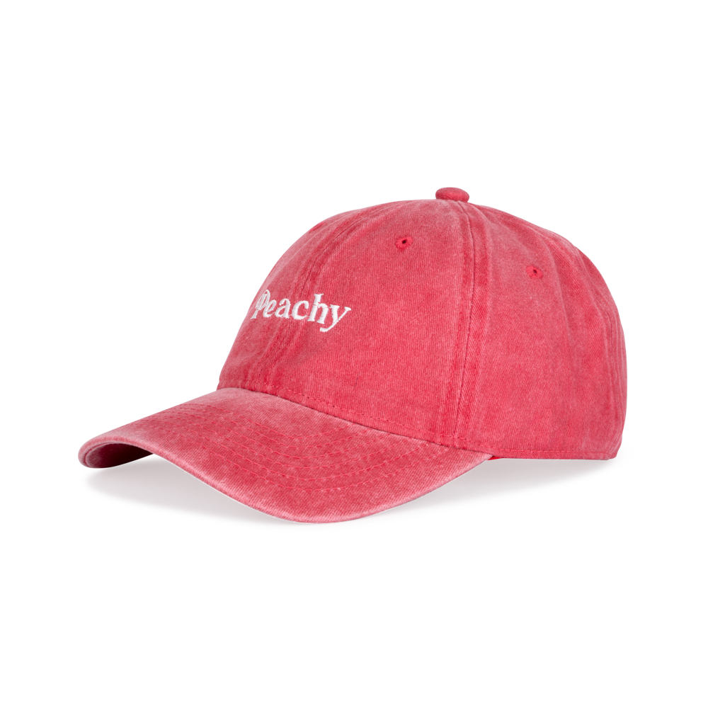 The Sui Ava Everyday Cap, Peachy, is a vintage-inspired washed red cap featuring "Peachy" embroidered in white on the front, shown against a plain white background.