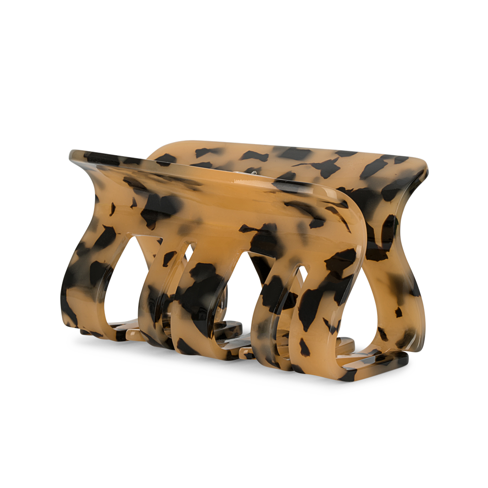 The Fie Siesta Big Hair Claw Clip in Light Tortoise by Sui Ava is a large acetate accessory with a curved prong design and a light tortoiseshell pattern in tan and black hues, displayed against a plain white background.