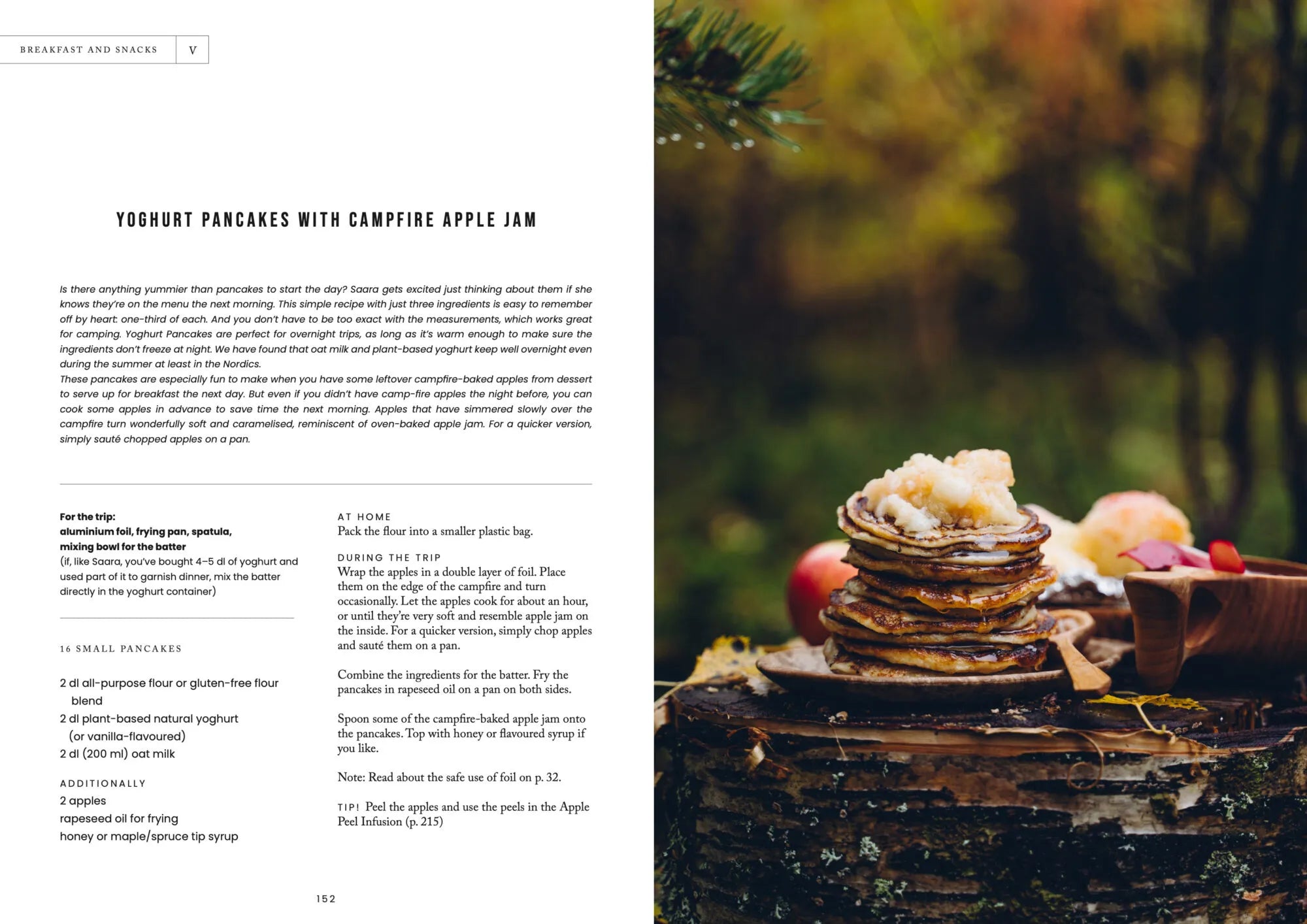 A stack of pancakes topped with apple jam rests on a rustic wooden surface outdoors, surrounded by fresh apples, pine needles, and blurred greenery in the background—capturing the inviting atmosphere of a campfire breakfast inspired by classic recipes from Food Over the Campfire – Recipes for Day Hikes and Wilderness Treks by Cozy Publishing.