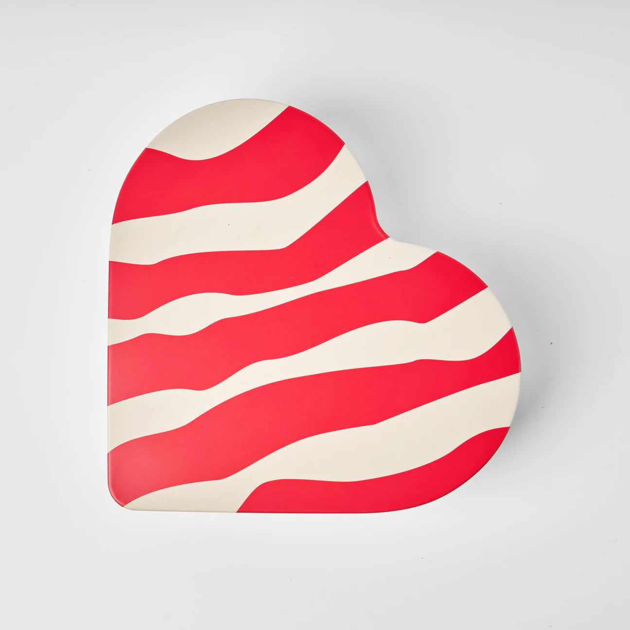 The Gåva Gifting Heart Reusable Tin - Älskar (Love), featuring wavy red and white stripes, sits on a plain white background.