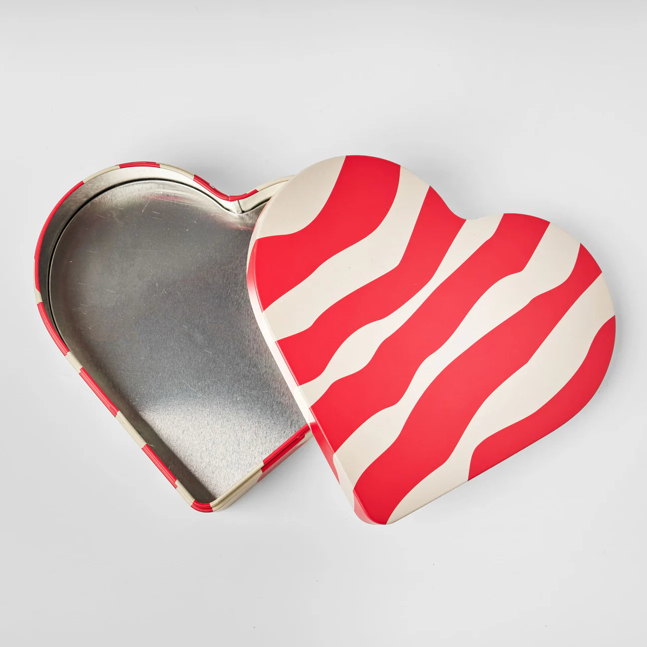 The Heart Reusable Tin - Älskar (Love) by Gåva Gifting features a red and white wavy striped lid and is perfect for sharing Swedish candy or storing sweet treasures, making it an ideal charming gift tin.